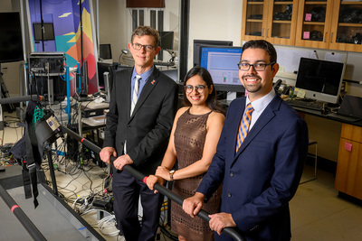 Three researchers posed in their research lab
