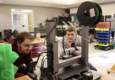 two students are using high-tech equipment in a lab