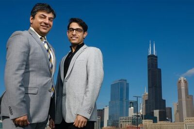 two men in suits posing in front of Chicago skyline