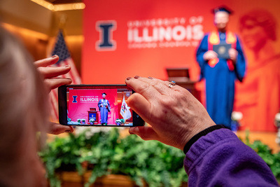 parent taking pic of graduate on mobile phone