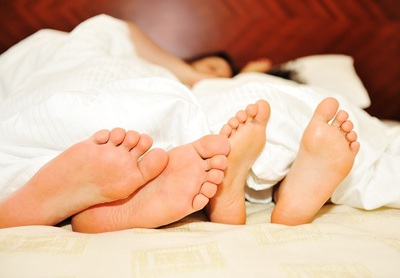 Couple in bed with only feet showing