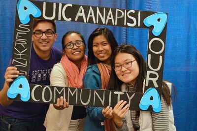 Asian students smiling holding a photo frame around their faces