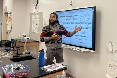 Black man teaching at white board
