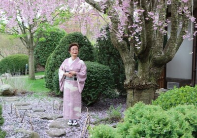 Professor Emeritus Kimiko Gunji poses near a Cherry Blossom tree at Japan House in Urbana.
