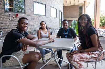Four Black students smiling around a table