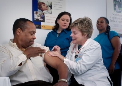 man receiving injection from doctor
