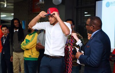 Reon Gillespie putting on UIC hat and necktie from 2018