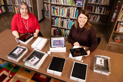 Sarah Isaacs, the librarian of the Early Intervention Clearinghouse, and research information specialist Jill Tompkins show some of the tablet computers and Wi-Fi hotspots available for loan