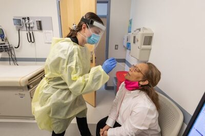 healthcare worker swabbing nostril of patient