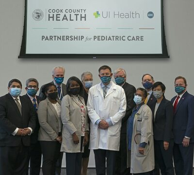 physicians and administrators posed in front of banner
