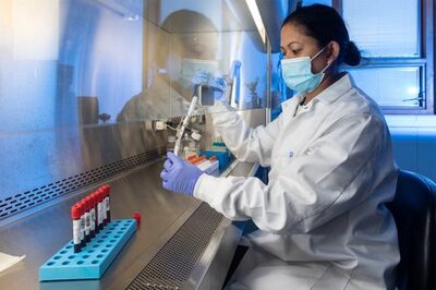 Scientists in the lab in white coats processing samples