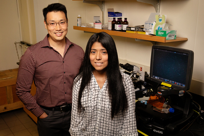 Male professor and female grad student pose in lab