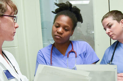 three nurses looking at papers
