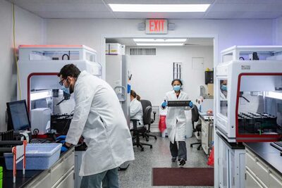 Scientists in the lab in white coats processing samples