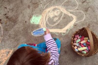 child drawing on sidewalk with colorful chalk