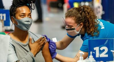 Female receiving vaccine from female nurse