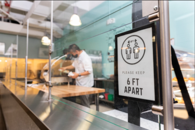 six feet apart sign in dining hall with worker