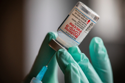 vaccine vial close up in gloved hand