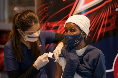 woman giving COVID-vaccination to resident