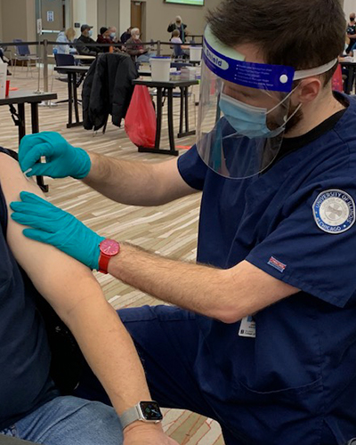 Jason Brooks administers COVID-19 vaccine