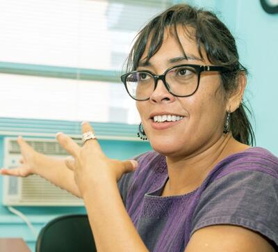 Woman in glasses talking in office