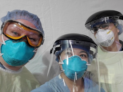 three smiling workers in PPE