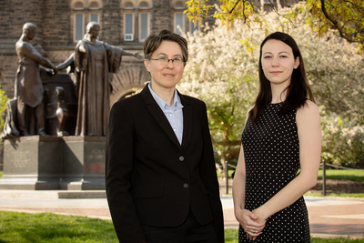 Female professor and female grad student pose in front of the Alma Mater on UIUC campus