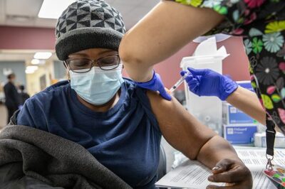 patient in hat and mask getting vaccination in arm