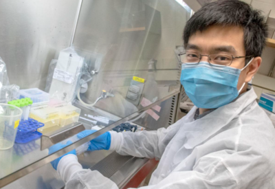 masked professor working in lab